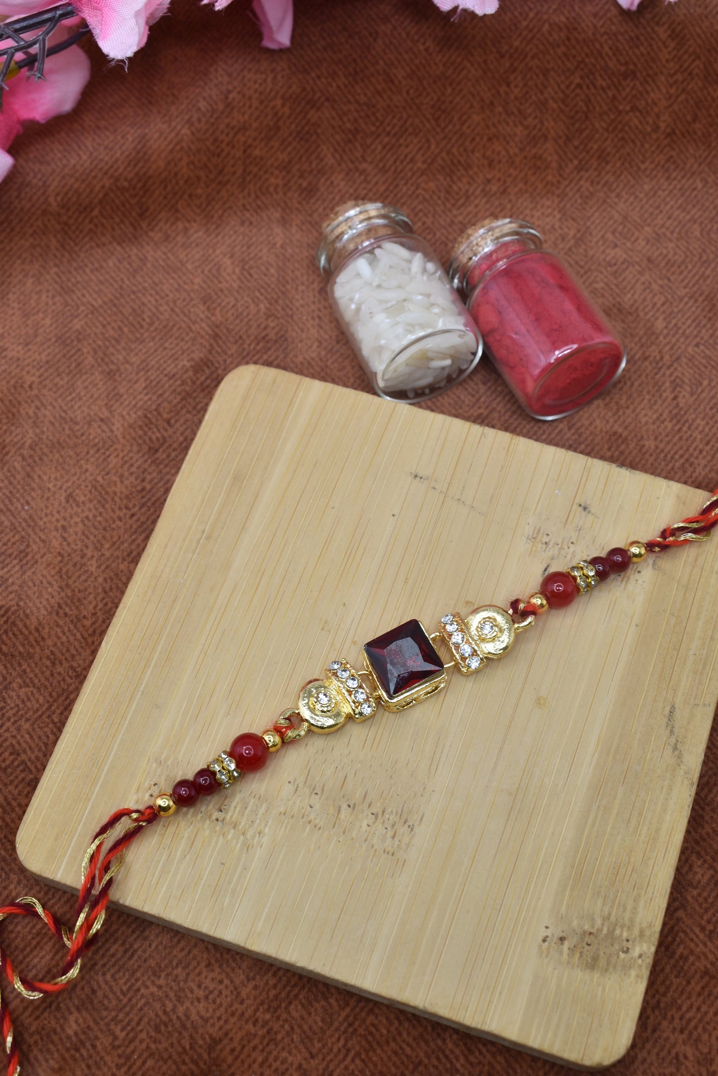 सोने की परत चढ़ी और लाल पत्थर से जड़ी राखी